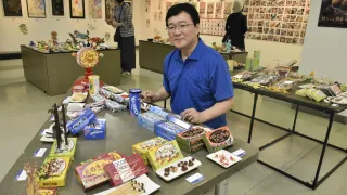 「お菓子のパロディ」などユーモアあふれる作品が並んだ橋村さん（中央）のアート展